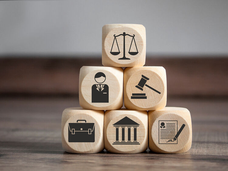 Wooden blocks stacked to show legal icons representing justice, law, and legal services